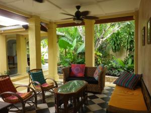 a screened in porch with chairs and a couch at Villa Papaya in Flying Fish Cove