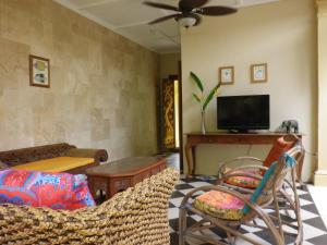 a living room with a couch and a tv at Villa Papaya in Flying Fish Cove