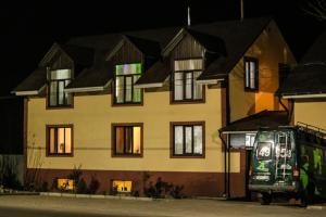 a bus parked in front of a house at night at Guest house Altay in Karakol