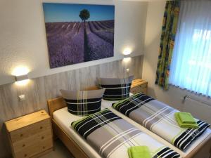 2 Betten in einem Zimmer mit einem Bild an der Wand in der Unterkunft Hotel Oelberg budget - BONN SÜD Königswinter in Königswinter