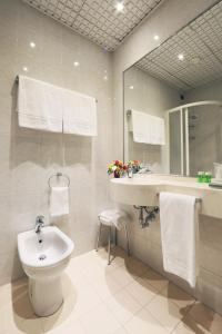 a bathroom with a sink and a toilet and a mirror at Hotel Campion in Milan