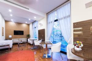 a living room with white furniture and a large window at Hotel Campion in Milan