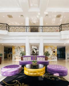a lobby with purple and yellow furniture and a fountain at Звездный Отель WELLNESS & SPA in Sochi