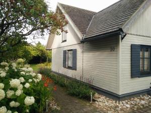 ein weißes Haus mit einem Fenster und ein paar Blumen in der Unterkunft Lembitu Holiday Home in Pärnu