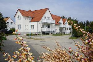 une rangée de maisons blanches aux toits rouges dans l'établissement Ferienwohnungen Rügen Findling Breege, à Breege