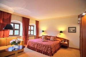 Romantik Hotel Bülow Residenz في درسدن: غرفه فندقيه بسرير واريكه