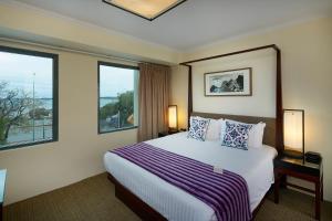 a hotel room with a bed and two windows at Pagoda Resort & Spa in Perth