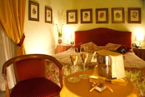 a room with a table with wine glasses and a bed at JOIVY Together Florence Secret Nest in Florence