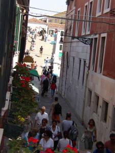 a group of people walking down a street at casettaveneziana02704 in Venice