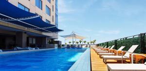 a swimming pool with lounge chairs next to a building at The Bellevue Manila in Manila