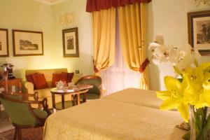 a hotel room with two beds and a table with flowers at JOIVY Together Florence Secret Nest in Florence
