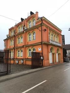 een groot oranje gebouw aan de straatkant bij Motel Vila Bakarni in Brčko