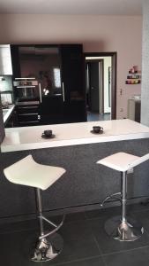 a kitchen with two stools and a white counter top at Villa Iris in Livadi