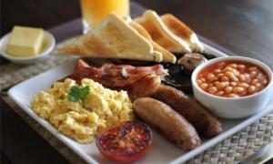 a plate of breakfast food with eggs sausage beans and toast at White City Inn in Gaborone