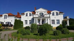 a large white house with a red roof at Pensjonat Błękitny Anioł in Kiersztanowo