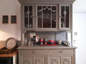 a large cabinet with glass doors in a kitchen at Ecluse de la Tindière in Nort-sur-Erdre