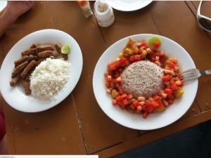 two plates of food with rice and vegetables on a table at New Imperial Hotel in Hikkaduwa