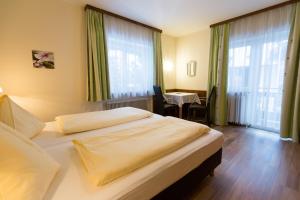 巴特霍夫加施泰因的住宿－Appartementhaus Lafenthaler mit kostenlosem Eintritt in Alpentherme，酒店客房设有两张床和一张桌子。