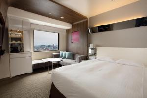 Postel nebo postele na pokoji v ubytování Kawasaki Nikko Hotel