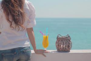 Brazzera Hotel في فينيكاس: امرأة تقف بجوار طاولة مع الشراب