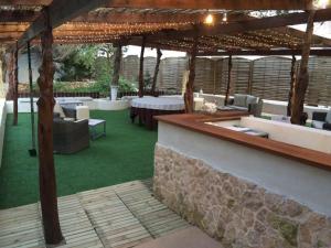 an outdoor patio with couches and a table and chairs at Hostal Capri in Es Pujols