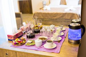 a table with a purple table cloth with cups and wine glasses at Hotel Holiday Villa in Tbilisi City