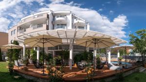 a large building with umbrellas in front of it at The Mint Villa - Saint Vlas in Sveti Vlas