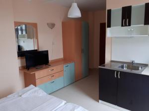 a room with a bed and a kitchen with a sink at Apart Hotel Ravda in Ravda
