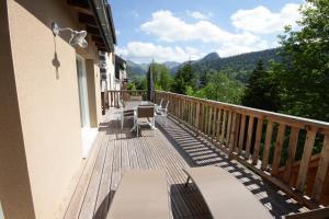 a balcony of a house with a table and chairs at L'Atelier de Claire in Le Mont-Dore