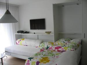a bedroom with a bed and a tv on the wall at Casa Irmella 16 in Arosa