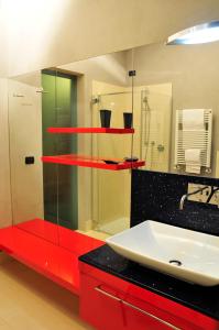 a bathroom with a red counter and a sink at Ai Lecci in Centro in Sarteano