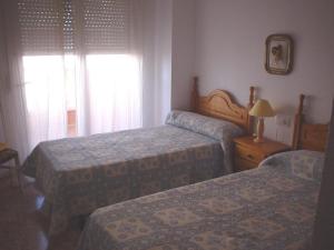 ラ・マンガ・デル・マール・メノールにあるBertur Isla Grosaのベッド2台と窓が備わるホテルルームです。