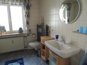 a bathroom with a sink and a toilet and a mirror at Ferienwohnung "Am alten Main" in Kemmern