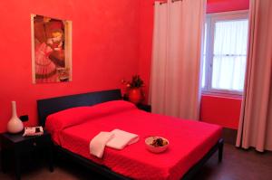 a red bedroom with a red bed with a bowl on it at Ai Lecci in Centro in Sarteano