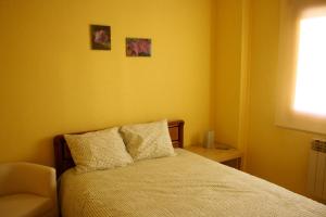 クエンカにあるEl Rincón del Violinistaのベッドルーム1室(壁に2枚の写真が飾られたベッド1台付)