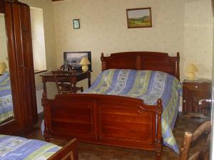 1 dormitorio con cama grande de madera y escritorio en lemoign-locations, en Crozon