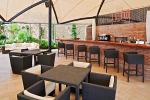 patio ze stołami i krzesłami oraz barem w obiekcie Senator Banus w mieście Estepona