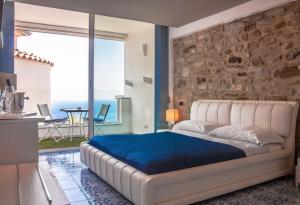 a bedroom with a white bed with a stone wall at Residenza D'epoca Tamara in Castellabate