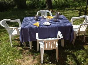 una mesa con mantel azul y sillas blancas en Casa Vacanze Valdicciola, en Suvereto