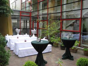 un groupe de tables devant un bâtiment dans l'établissement Hôtel Galerie, à Greifswald