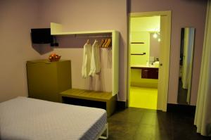 a bedroom with a bed and a bathroom with a sink at Ai Lecci in Centro in Sarteano