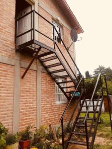 una escalera de madera que conduce a un balcón en una casa en Casa de Vero en Mina Clavero