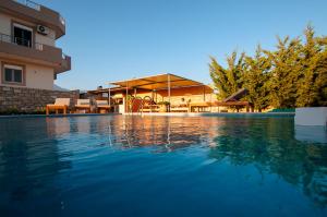 a swimming pool in front of a house at Elpidis Villa in Kokkinos Pirgos