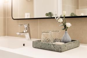 a bathroom sink with a vase with flowers in it at Elite Hotel Carolina Tower in Stockholm