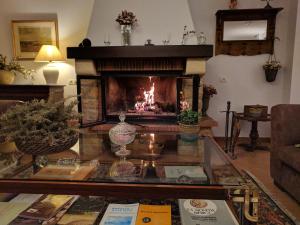 a living room with a fireplace and a glass table at Finca El Romeral in Alpera