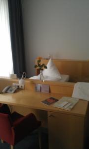 a desk in a hotel room with a bed and a desk sidx sidx sidx sidx at Hôtel Galerie in Greifswald +9 photos