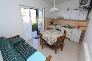 a kitchen and dining room with a table and a couch at Apartments Milka in Rovinj