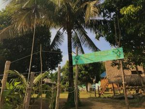 a street sign in front of a palm tree at Lazy Bones in Koh Rong Sanloem