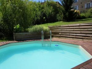 een groot zwembad in een tuin met een huis bij La Petite Auberge in Carennac