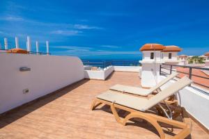 a balcony with two lounge chairs on a roof at Los Olivos Beach Resort in Adeje +106 photos